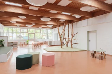 Kindergartenmöbel und Raumgestaltung: Große Piazza oder Gemeinschaftsraum in der Kita, vielseitig nutzbar als Essbereich, Bühne und für Kletterbäume, ideal für gemeinsames Spielen und Zusammenkommen.