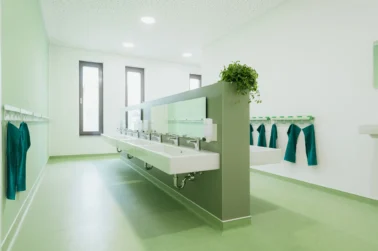 Waschraum im Kindergarten Kindergartenmöbel im Bad einer Kita: Wandhängende Zahnputzbecherhalter von Papoq für funktionale und hygienische Gestaltung.